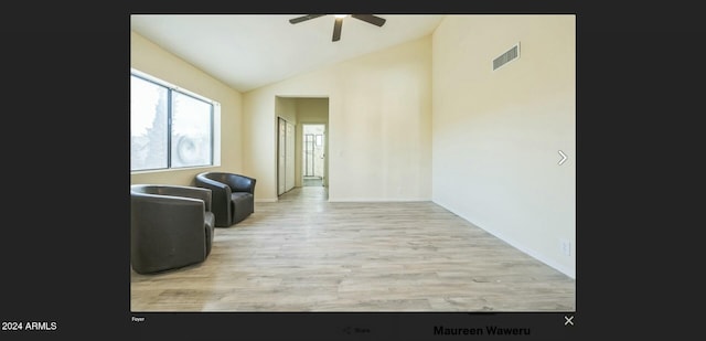 living room featuring ceiling fan, lofted ceiling, and light hardwood / wood-style flooring