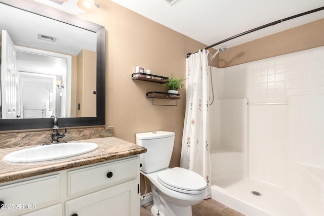 bathroom featuring a shower with curtain, toilet, and vanity