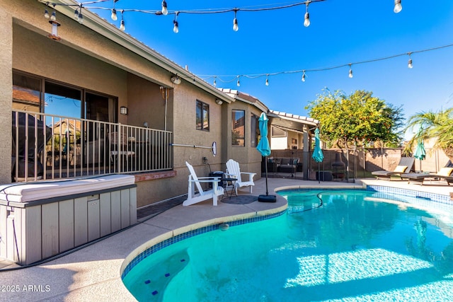 view of swimming pool featuring a hot tub and a patio