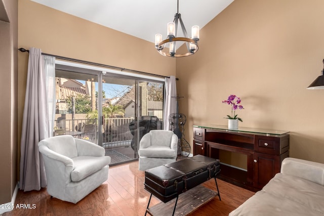 living room with a notable chandelier, high vaulted ceiling, and hardwood / wood-style flooring