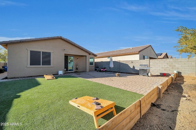 back of house with a yard and a patio