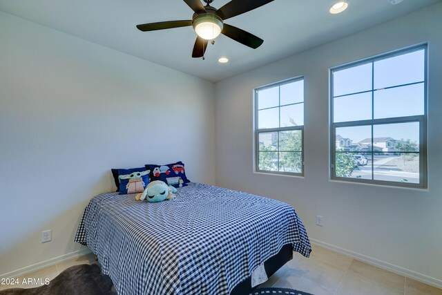 tiled bedroom featuring ceiling fan