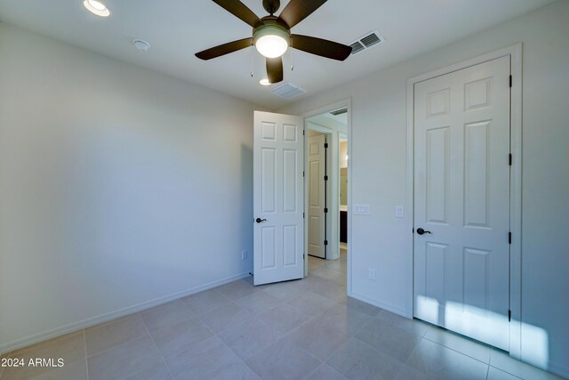 unfurnished bedroom featuring light tile patterned floors, ceiling fan, and a closet