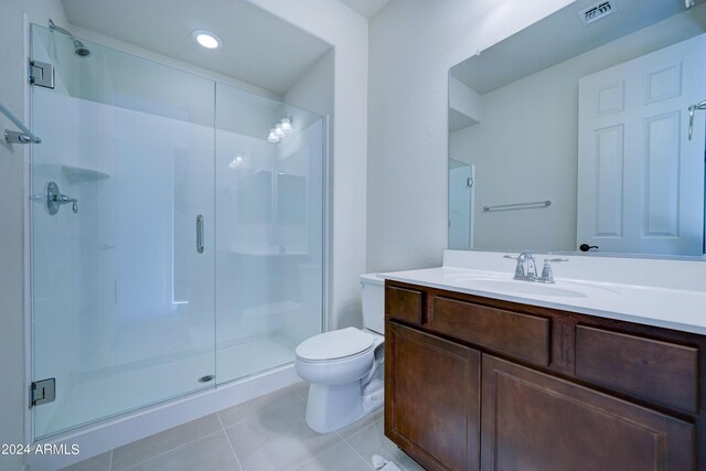 bathroom with vanity, tile patterned flooring, toilet, and an enclosed shower