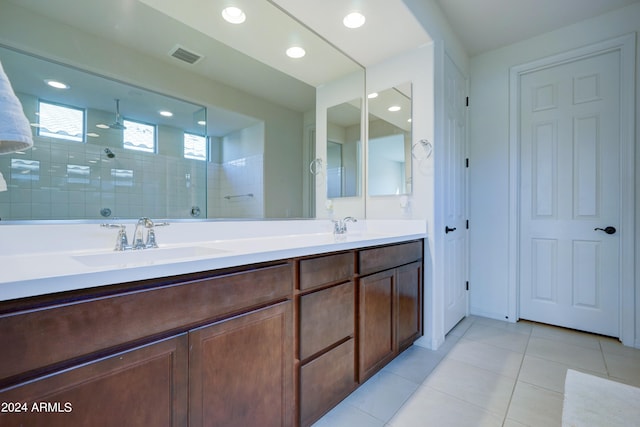 bathroom featuring a tile shower, vanity, and tile patterned floors