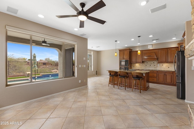 41627 N Cedar Chase Rd, Anthem, AZ 85086 - kitchen featuring black microwave, custom range hood, ceiling fan, a sink, and brown cabinetry