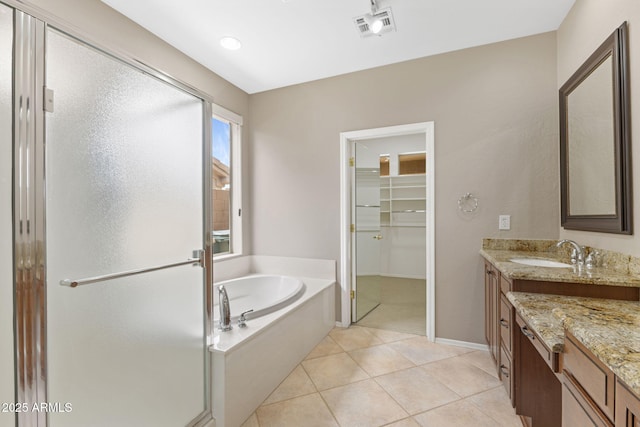 41627 N Cedar Chase Rd, Anthem, AZ 85086 - bathroom with vanity, a garden tub, a walk in closet, a stall shower, and tile patterned flooring
