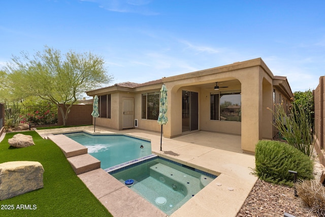 41627 N Cedar Chase Rd, Anthem, AZ 85086 - back of property featuring a ceiling fan, a patio area, stucco siding, a fenced backyard, and a pool with connected hot tub