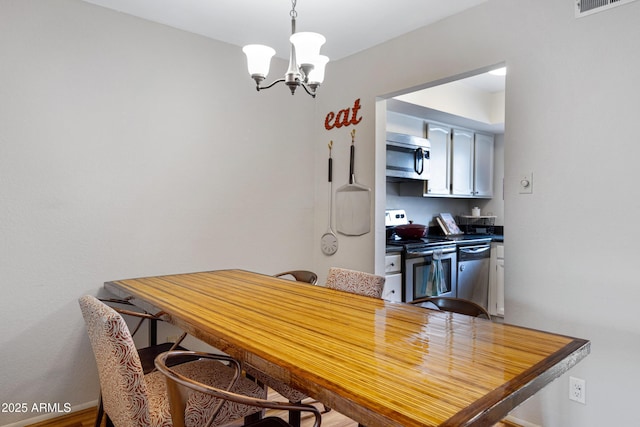 dining room featuring a chandelier and baseboards