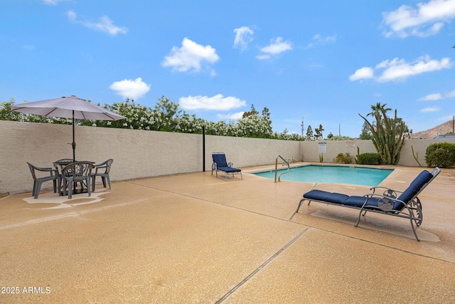 view of pool with a fenced backyard and a patio