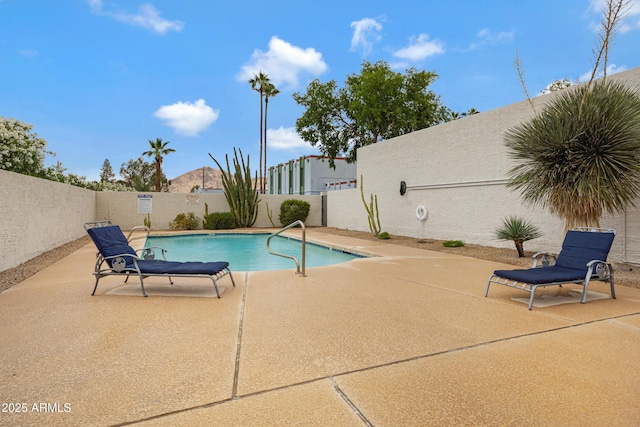 community pool featuring a fenced backyard and a patio
