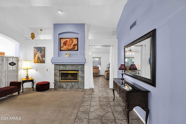 carpeted living room with a fireplace and ceiling fan