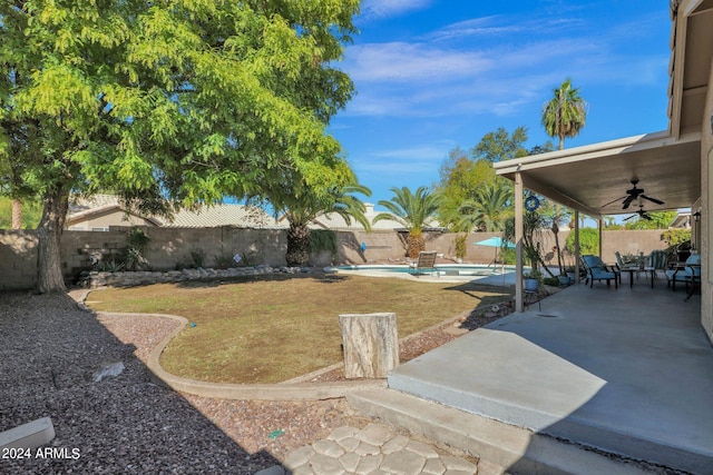 view of yard featuring a patio, a fenced in pool, and ceiling fan