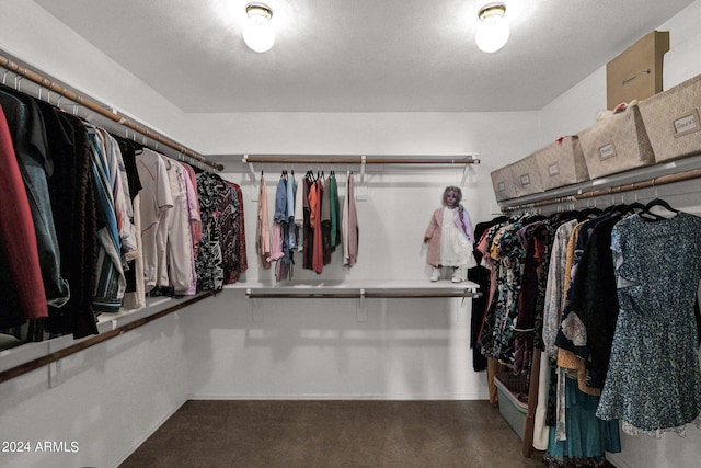 walk in closet with dark colored carpet