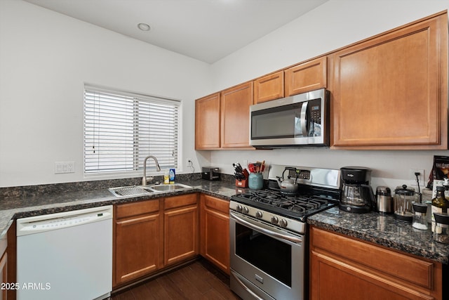 kitchen featuring appliances with stainless steel finishes, dark wood-style flooring, brown cabinets, and a sink