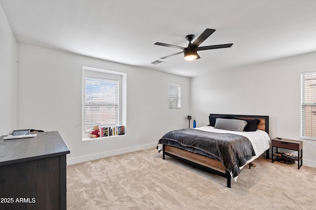 bedroom featuring visible vents, multiple windows, baseboards, and light colored carpet