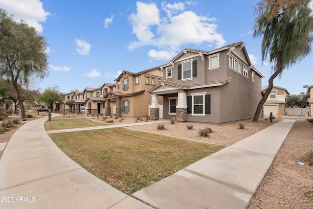 view of front of house featuring stone siding, a tiled roof, a residential view, stucco siding, and a front yard