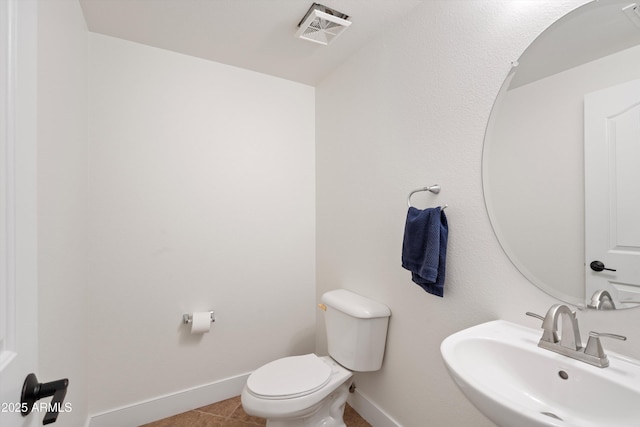 bathroom with visible vents, toilet, a sink, baseboards, and tile patterned floors