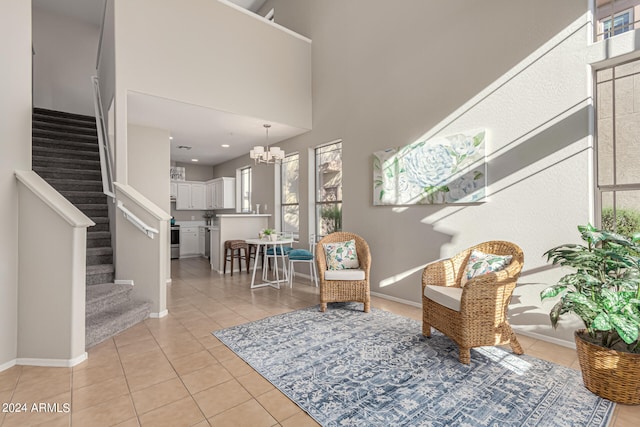 living area with an inviting chandelier, a high ceiling, and light tile patterned floors