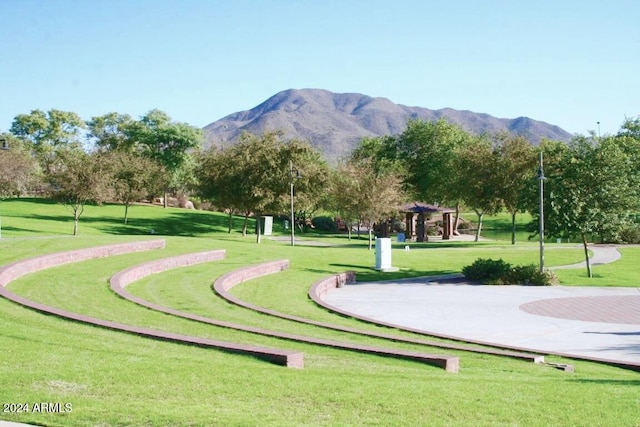 surrounding community with a mountain view and a lawn