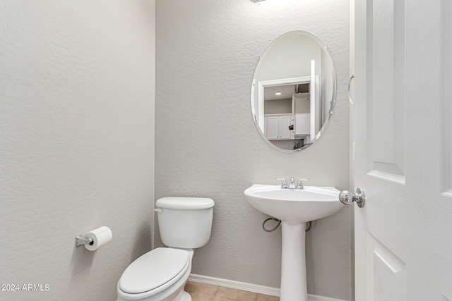 bathroom with sink, toilet, and tile patterned flooring