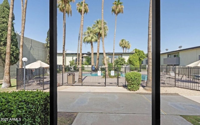 exterior space with a community pool and fence