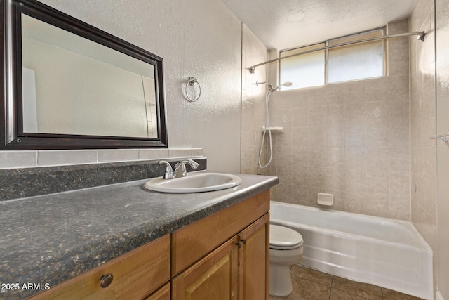 bathroom with bathing tub / shower combination, toilet, a textured ceiling, vanity, and tile patterned flooring