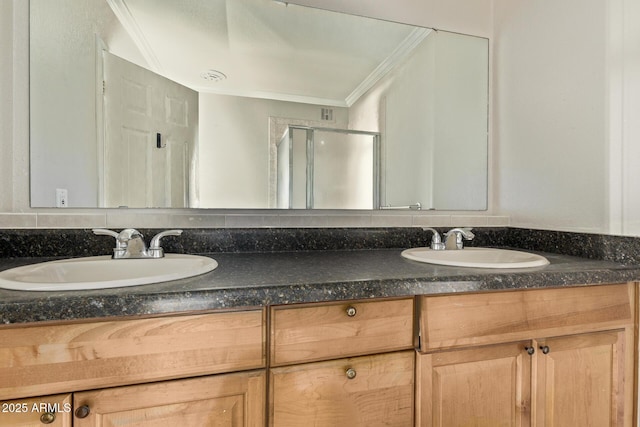 bathroom with ornamental molding, a sink, a shower stall, and double vanity