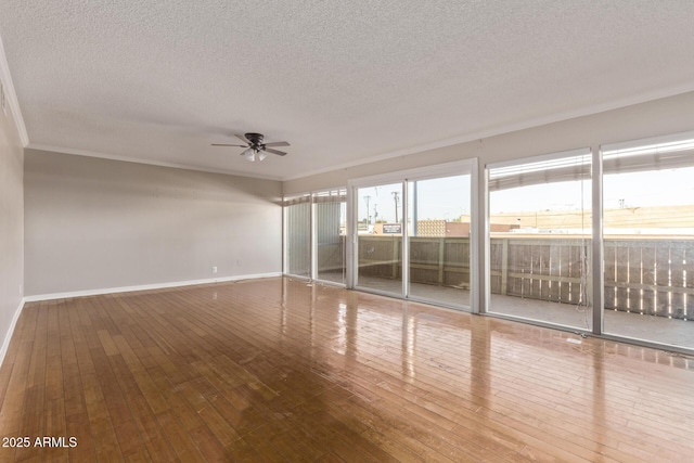 spare room with ceiling fan, a textured ceiling, baseboards, and hardwood / wood-style floors