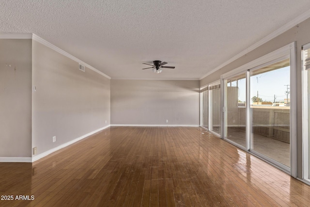 empty room featuring ornamental molding, baseboards, and hardwood / wood-style flooring