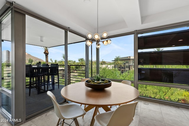 sunroom featuring a notable chandelier and a tray ceiling