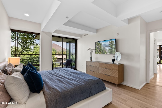 bedroom featuring beam ceiling, light wood-type flooring, and access to outside