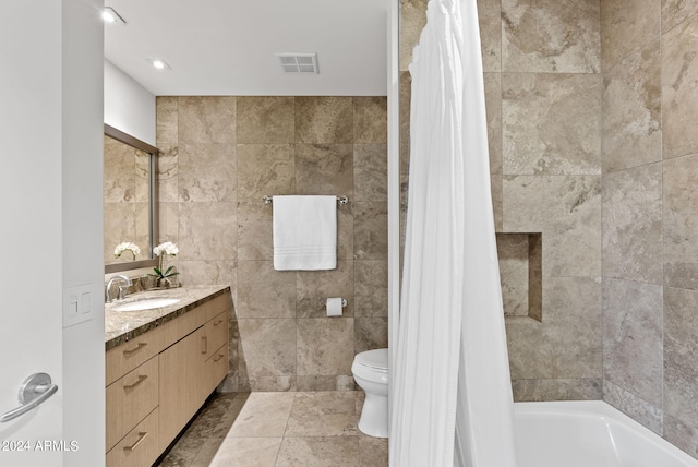 full bathroom with vanity, shower / bath combination with curtain, tile walls, and toilet