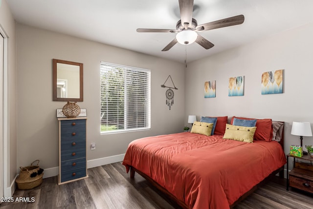 bedroom with a ceiling fan, baseboards, and dark wood-type flooring