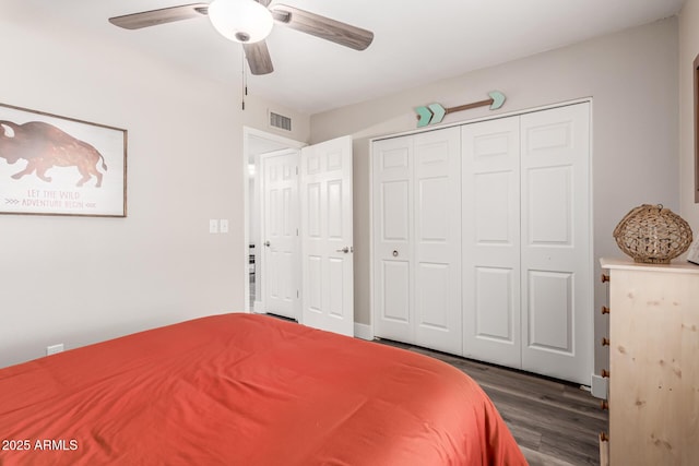 bedroom with ceiling fan, a closet, wood finished floors, and visible vents