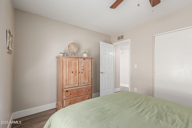 bedroom with baseboards, a ceiling fan, wood finished floors, and visible vents
