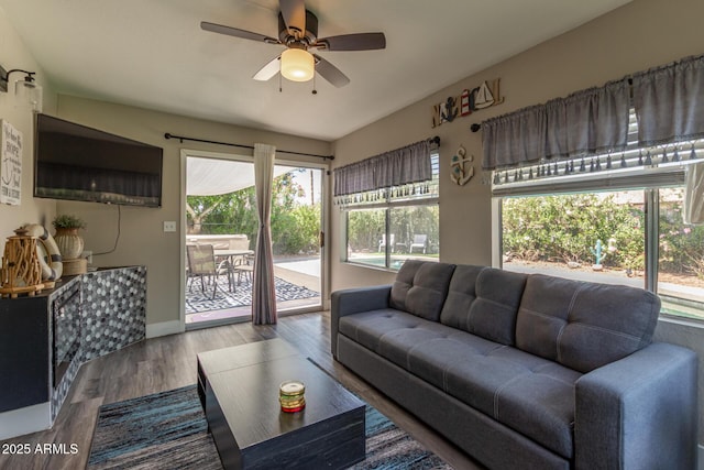 living area with a ceiling fan, baseboards, and wood finished floors