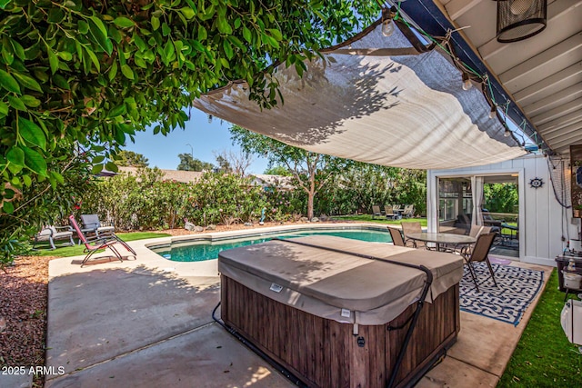 pool with a patio and a hot tub