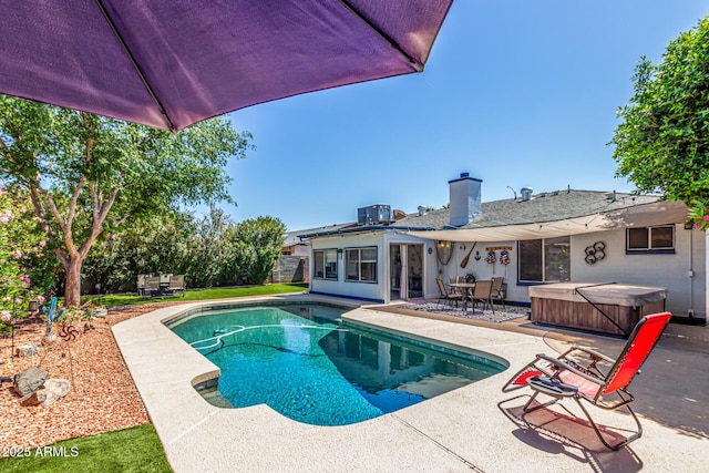 outdoor pool featuring fence, a hot tub, central AC, outdoor dining area, and a patio area