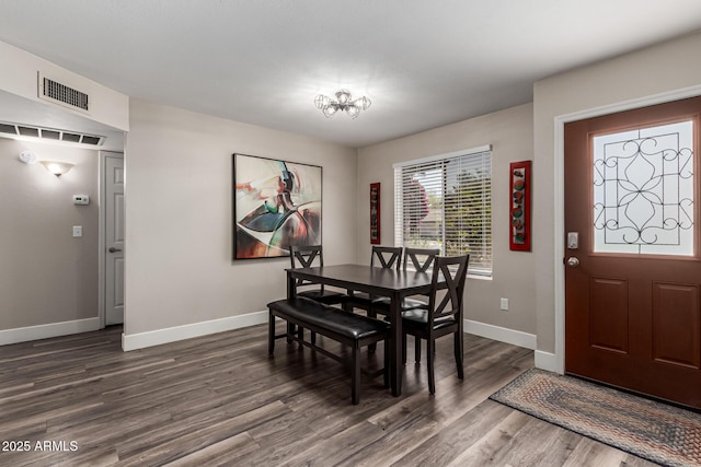 dining area featuring a notable chandelier, baseboards, visible vents, and dark wood finished floors