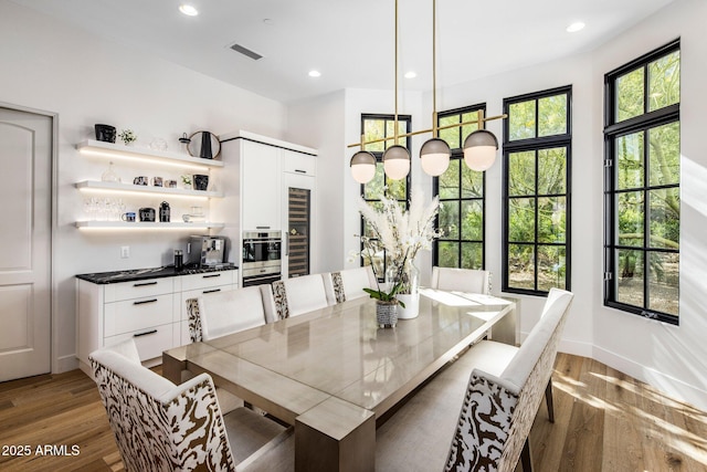 dining room featuring baseboards, light wood-type flooring, visible vents, and recessed lighting