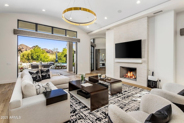 living room featuring a fireplace, recessed lighting, visible vents, baseboards, and hardwood / wood-style flooring