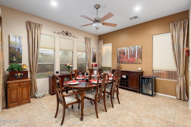 dining space featuring beverage cooler, light tile patterned flooring, and ceiling fan