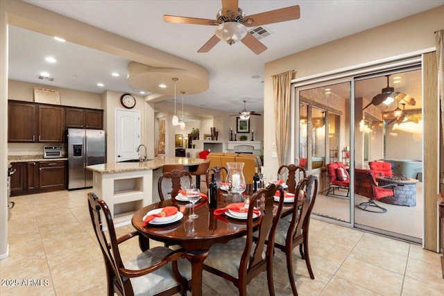 tiled dining room featuring sink and ceiling fan