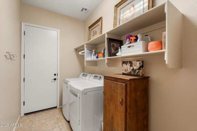 laundry room featuring washing machine and clothes dryer and light tile patterned floors