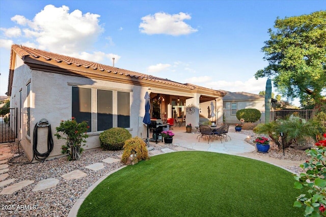 rear view of house featuring a yard and a patio