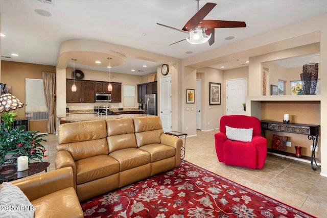 living room with ceiling fan and sink