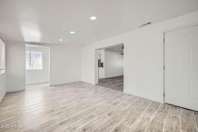 unfurnished room featuring wood tiled floor, visible vents, baseboards, and recessed lighting