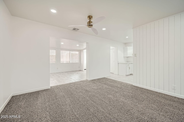 unfurnished living room featuring light carpet, visible vents, baseboards, ceiling fan, and recessed lighting