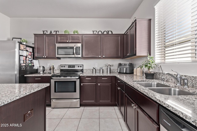 4741 E Fire Opal Ln, San Tan Valley, AZ 85143 - kitchen featuring stainless steel appliances, a sink, light tile patterned flooring, light stone counters, and dark brown cabinetry